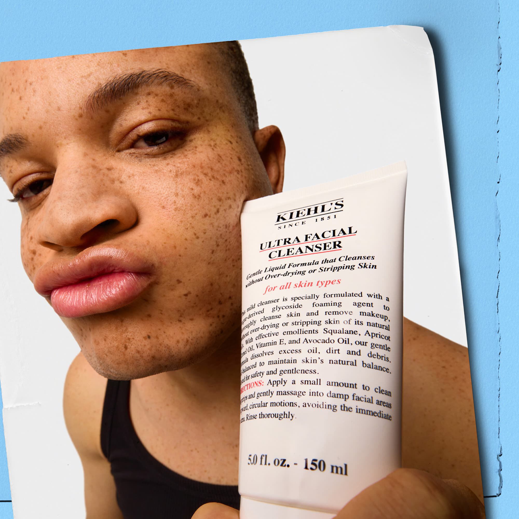 Model care ține un tub de Kiehl's Ultra Facial Cleanser