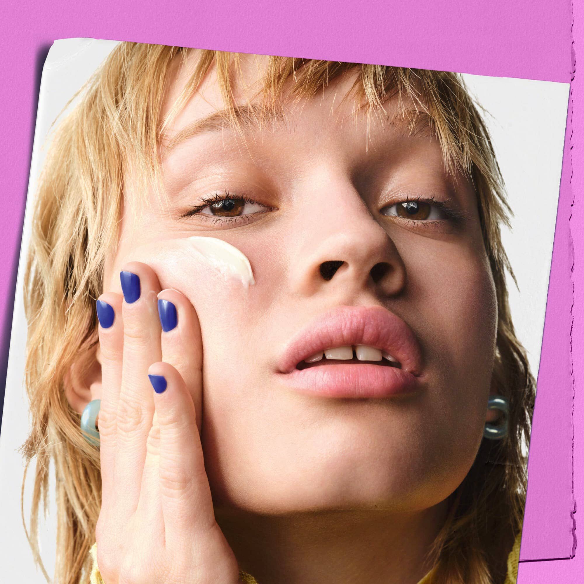 Model care aplică Kiehl's Super Multi-Corrective Cream pe obraz