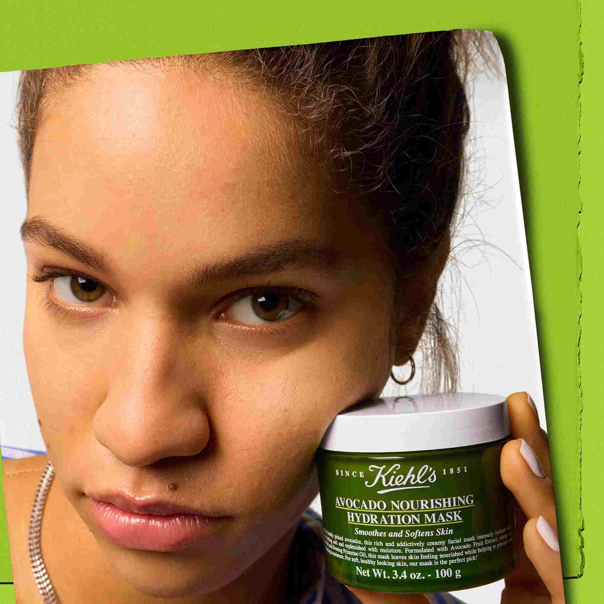 Model care ține un borcan de Kiehl's Avocado Nourishing Hydration Mask - netezește și catifelează pielea