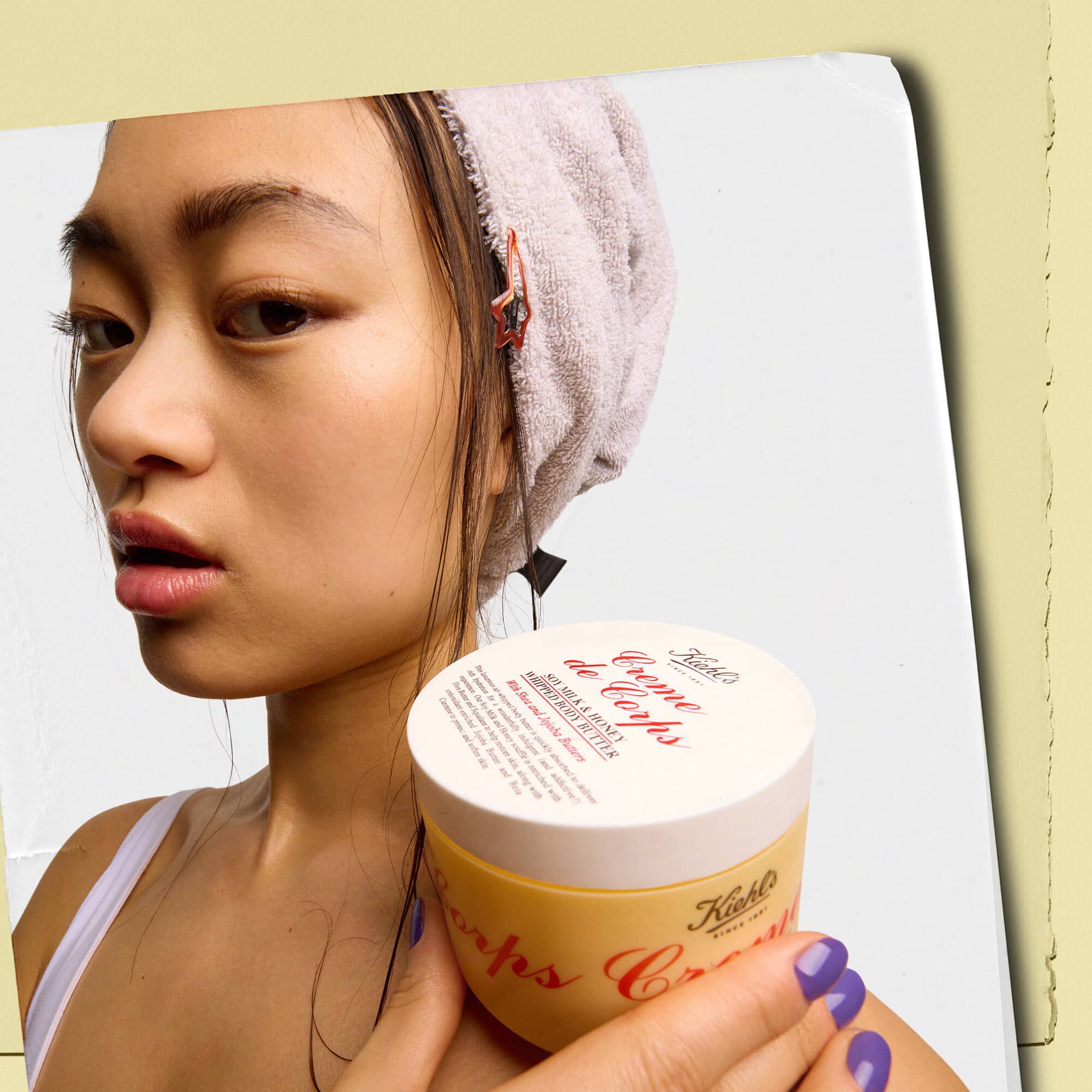 Model care ține un borcan de unt de corp Kiehl's Creme de Corps Whipped Butter