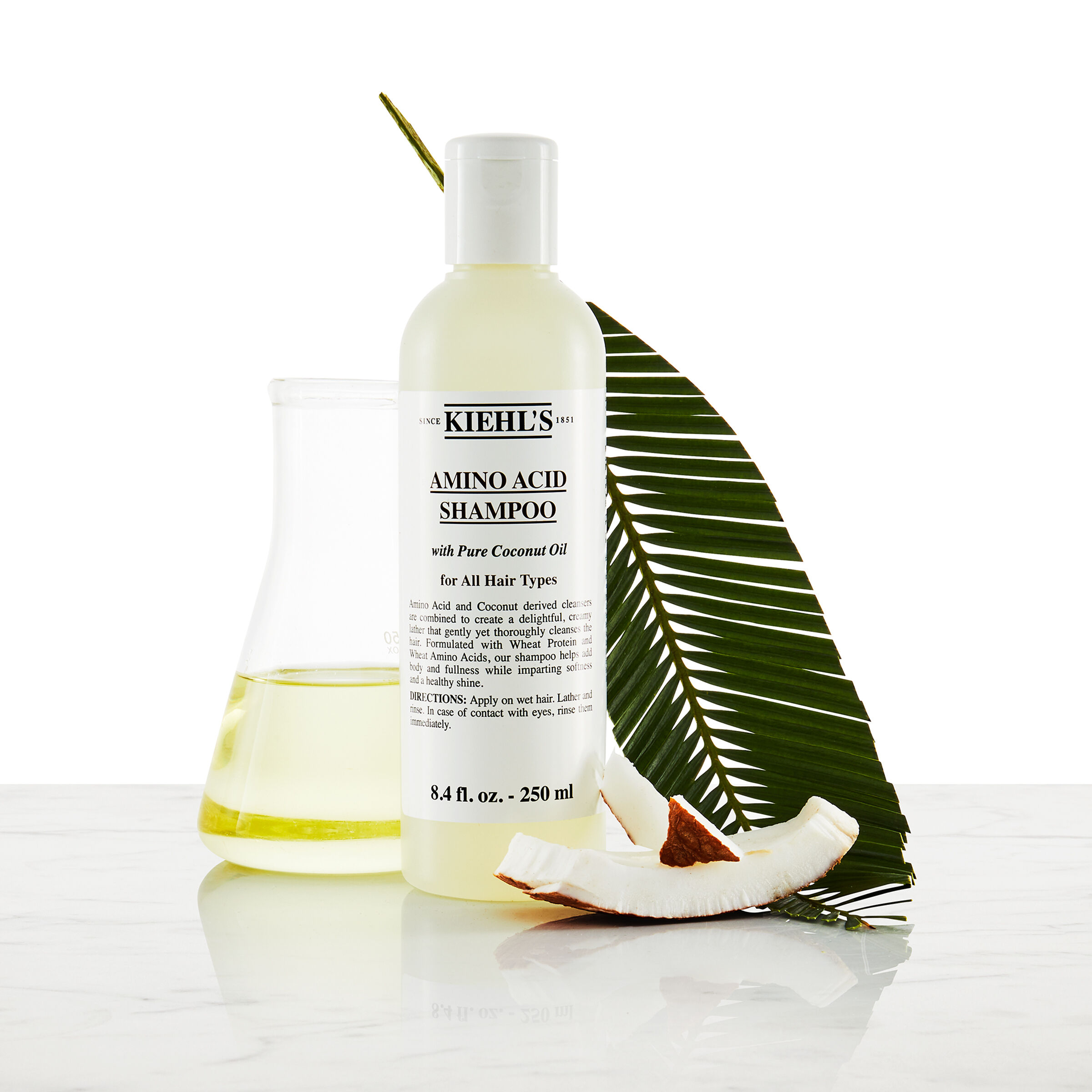 Model cu mustață și o sticlă de șampon Kiehl's Amino Acid Shampoo