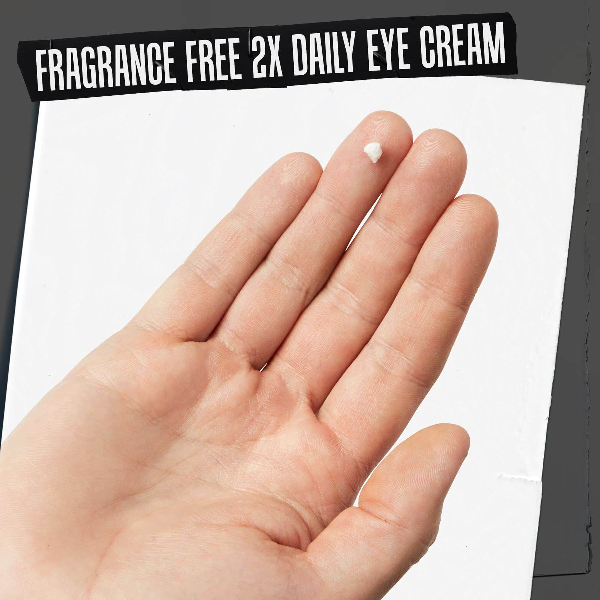 O mană cu textura cremei Age Defender Eye Repair etichetată „Cremă de ochi fără parfum, utilizare de 2 ori pe zi”.