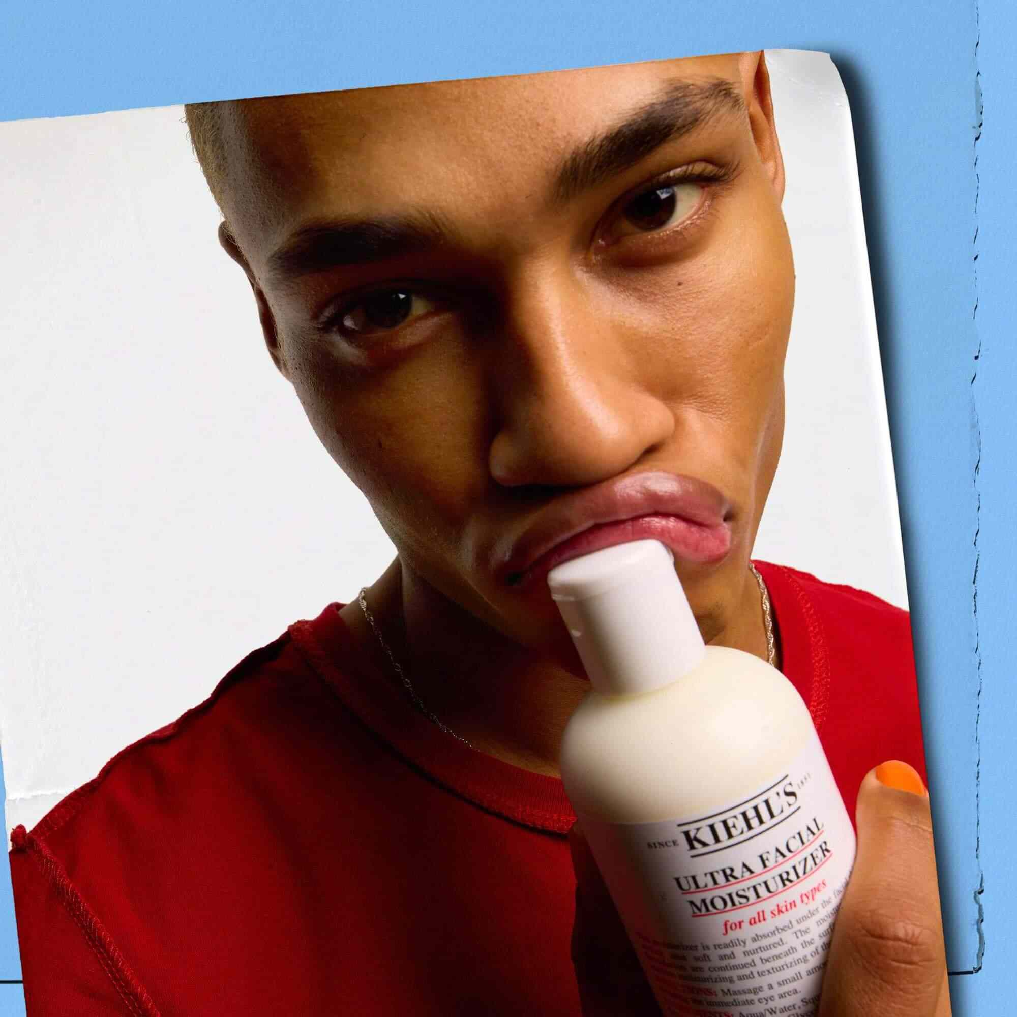 Model care apasă un flacon de Kiehl's Ultra Facial Moisturizer pe buze