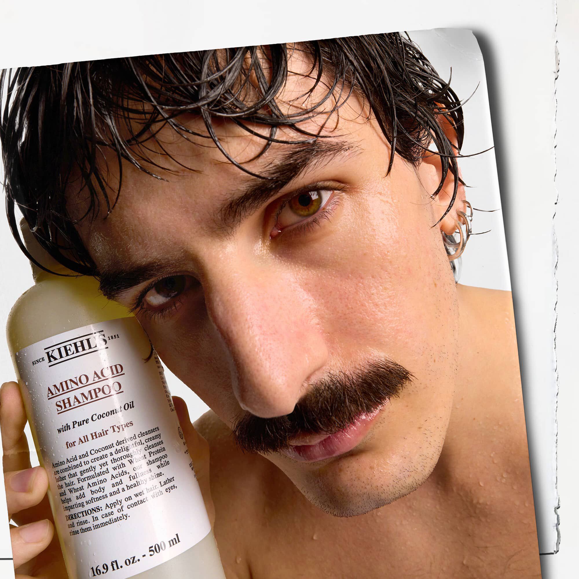 Model cu mustață și o sticlă de șampon Kiehl's Amino Acid Shampoo