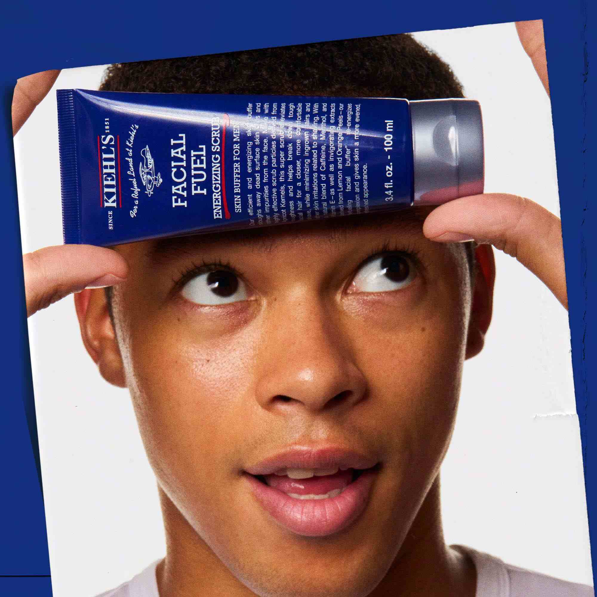 Facial Fuel Energizing Scrub ținut in mană, demonstrand utilizarea sa.