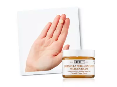 Crema hidratantă cu ser din flori de gălbenele, prezentată pe o palmă. Ambalajul este un borcan cu capac alb.