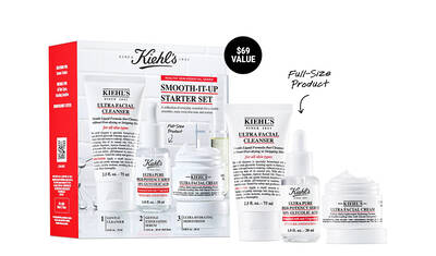 A Kiehl's Smooth-It-Up Starter Set displayed in its packaging, featuring four skincare products: a facial cleanser, two serums, and a facial cream, all labeled with their respective names and sizes. The set highlights its full-size product and a $69 value.