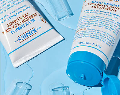 Produse de ingrijire a pielii Kiehl's, amplasate pe un fundal albastru, evidențiind textura și ambalajul.