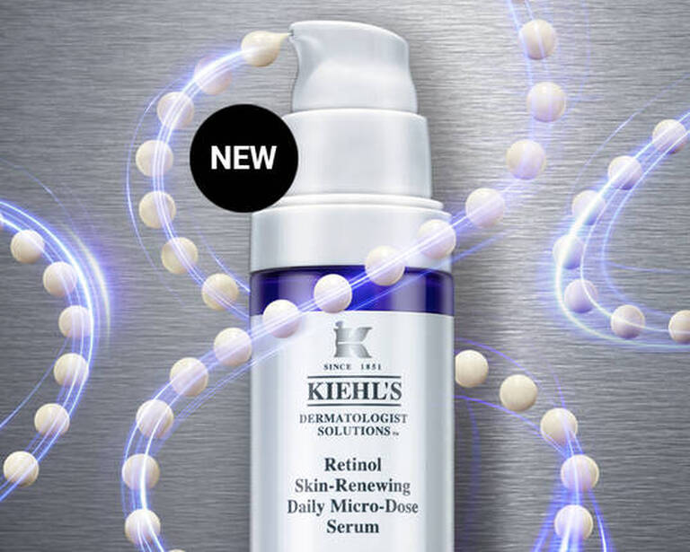 Serul Kiehl's cu retinol pentru imbunătățirea pielii, prezentat pe un fundal metalic cu capsule dispersate.