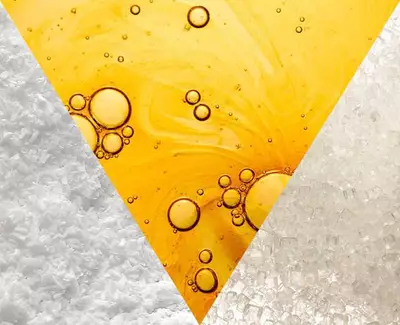 A triangular collage featuring three sections: one with coarse sea salt, another with golden liquid bubbles resembling oil, and the third with fine white sugar crystals.